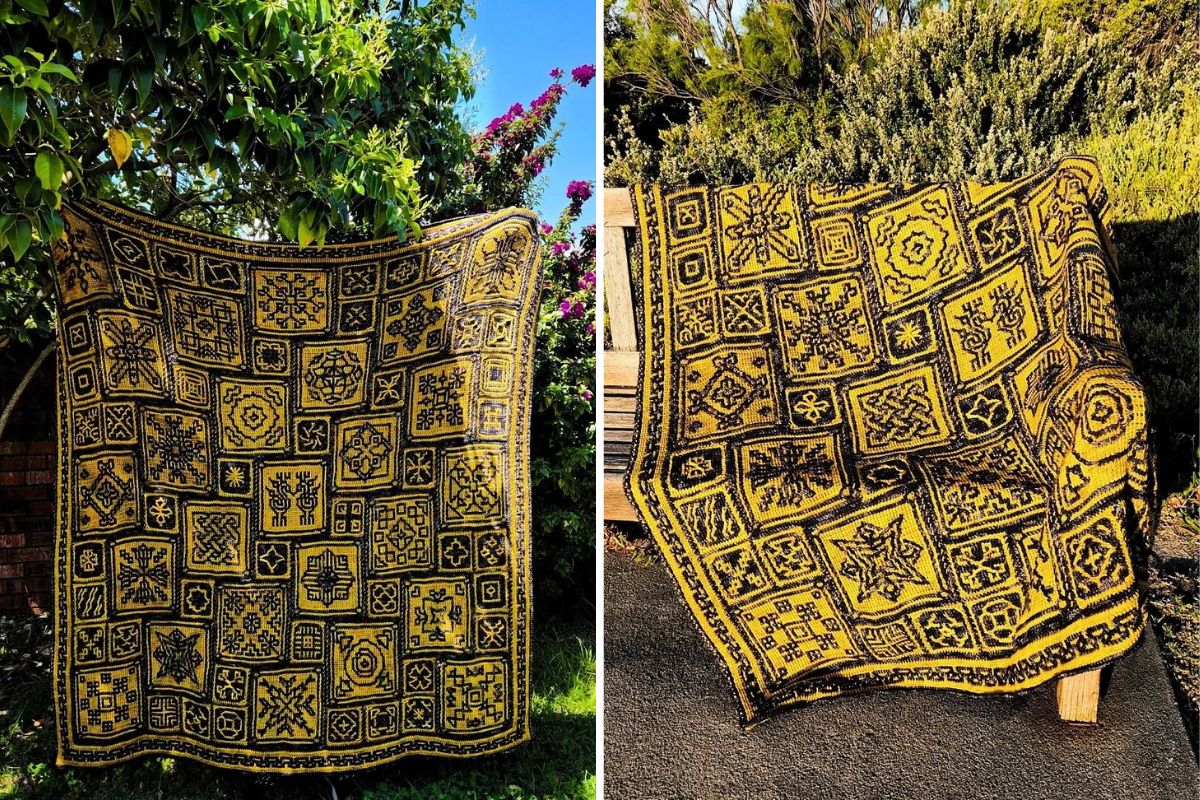 Two Tunisian blankets, with intricate geometric patterns in yellow and black, are elegantly crocheted and displayed outdoors against lush greenery and a rustic wooden fence.