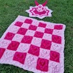 a crochet popcorn heart blanket made of squares in pink colors
