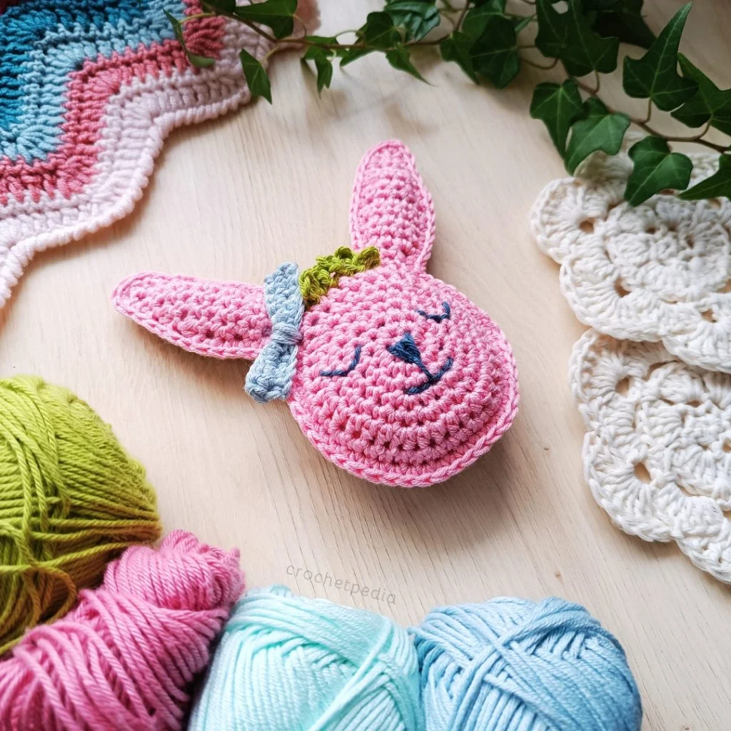 ragdoll bunny head among yarn and crochet projects