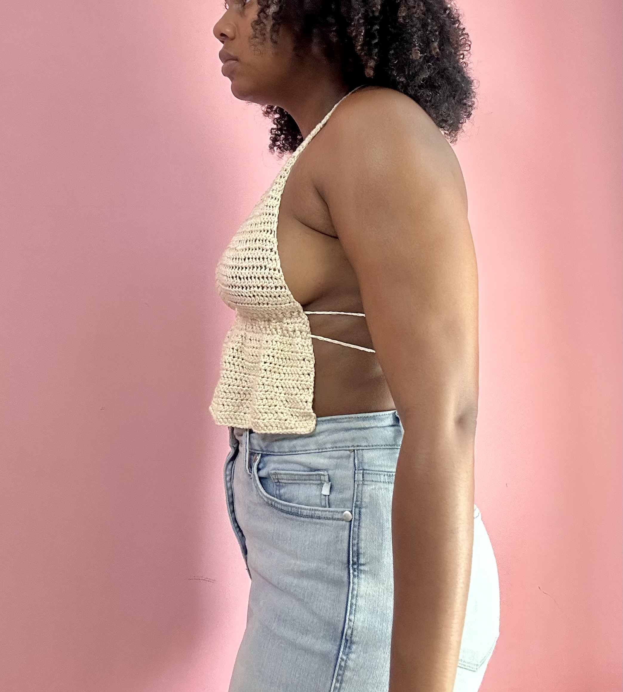side view of a woman weraing white crochet top