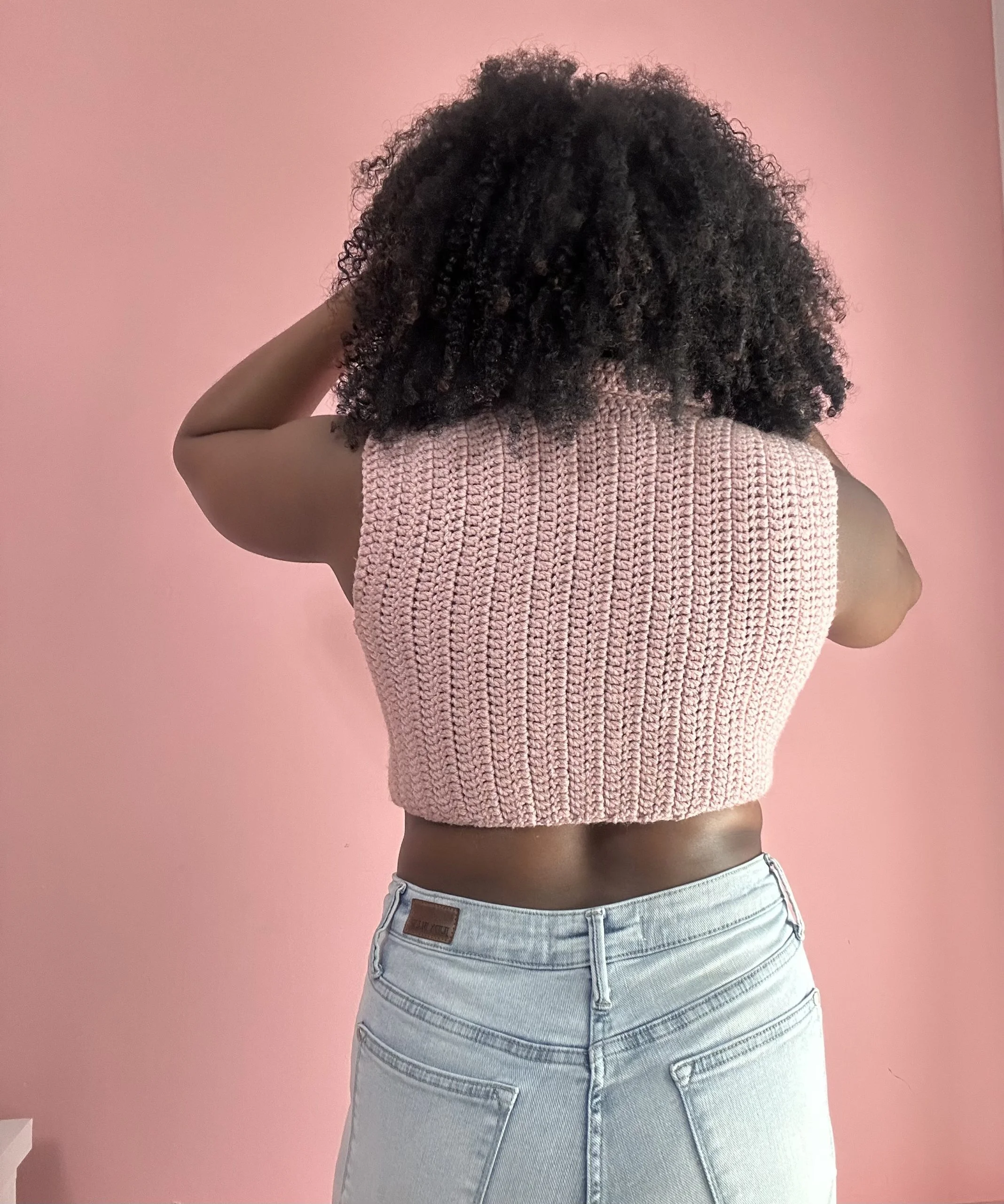 back of a woman wearing pink crochet top