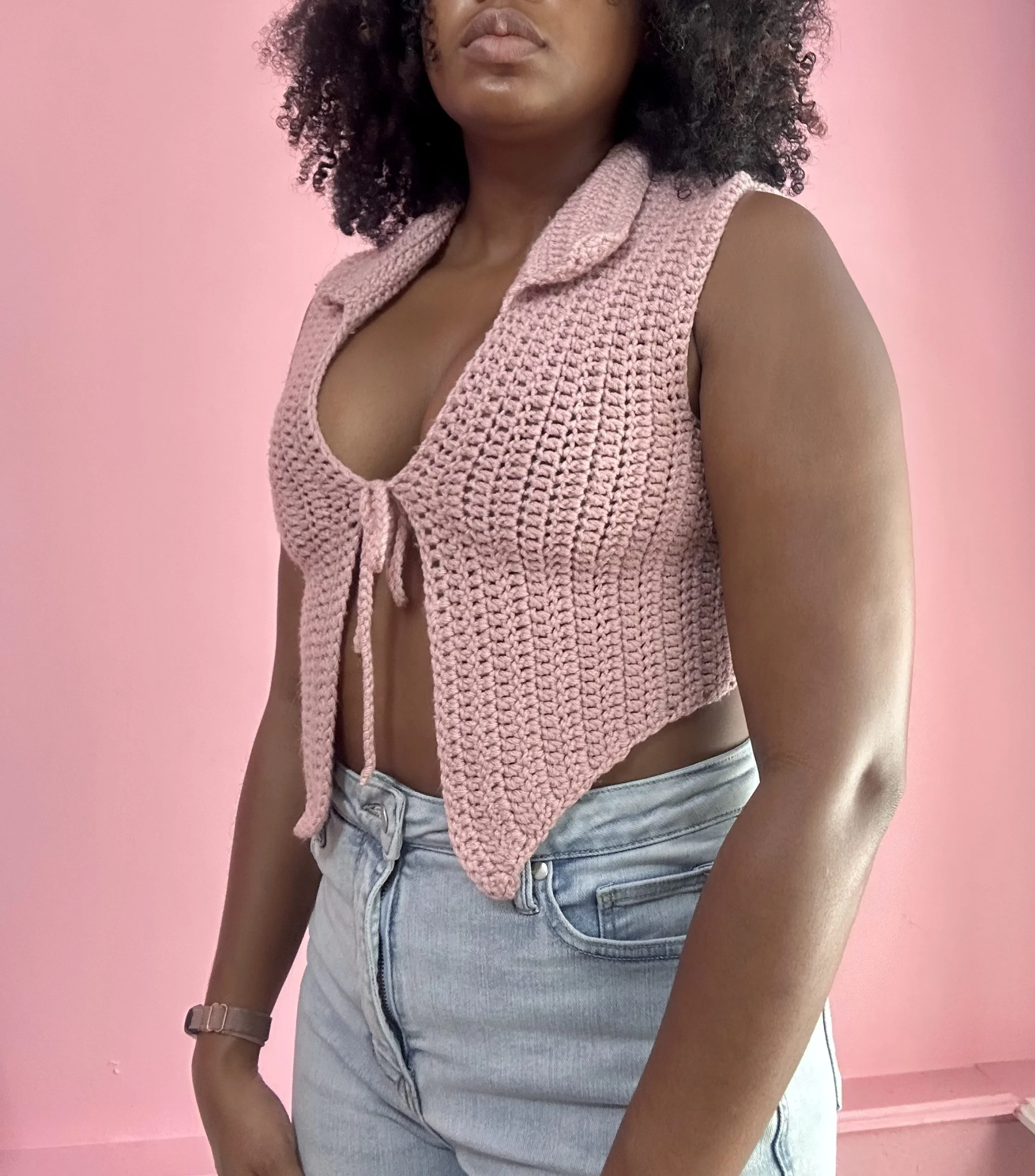 side view of a woman wearing tie front crochet top in pink color
