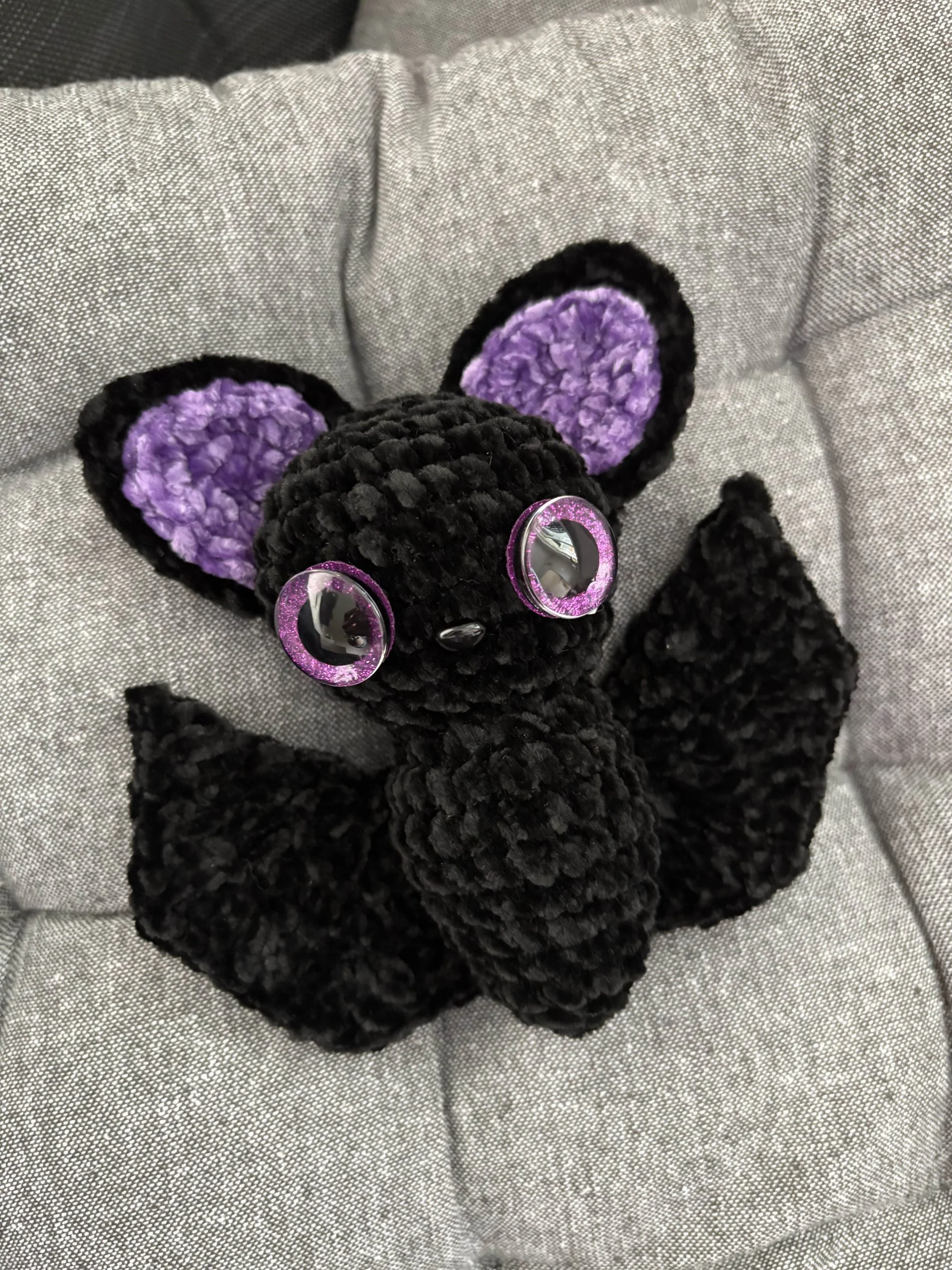 crochet amigurumi bat with black body and purple ears