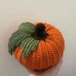 hand holding crochet pumpkin