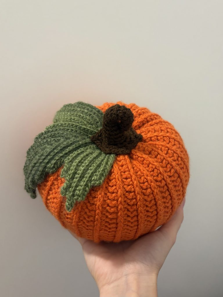 hand holding crochet pumpkin