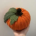 hand holding crochet pumpkin