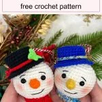 Two crocheted snowman ornaments from Cuddly Stitches Craft, each with charming hats and scarves—one red-and-black, one blue-and-white—are held in hand, surrounded by festive greenery and decorations.
