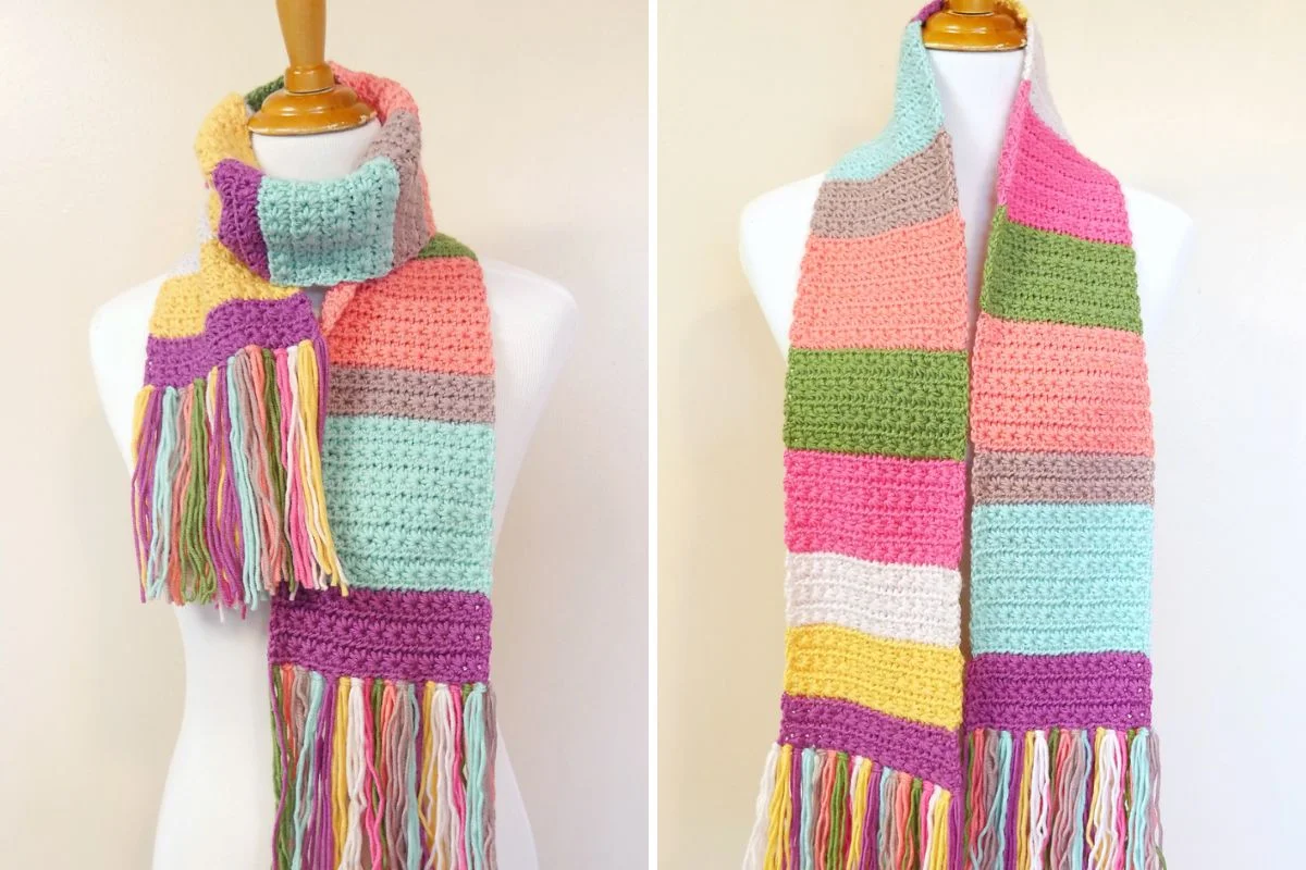 The Sweet Shop Scarf is a crocheted accessory with horizontal pastel stripes and multicolored fringe, displayed on a mannequin from two different angles.