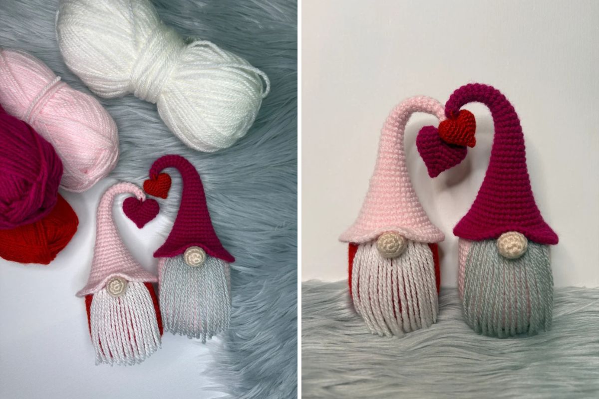 Two crocheted Valentine’s Day Gnomes with long beards and tall hats, joined by a red heart, are surrounded by balls of yarn on a gray furry surface.