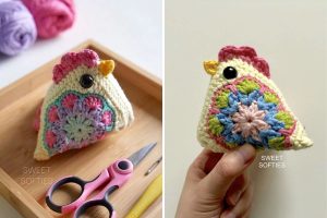 A crocheted chicken plush with colorful floral patterns, black button eyes, and a pink comb, shown on a wooden tray with scissors and yarn, and held in a hand.