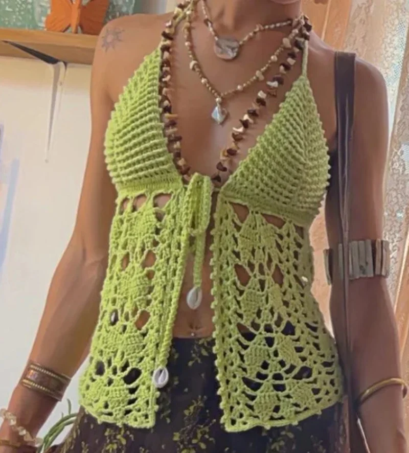 Person wearing a green crochet halter top with a tie front, layered necklaces, bracelets, and a brown skirt with a floral pattern—a perfect look for anyone building a handmade wardrobe or seeking Crochet Boho Tops inspiration.