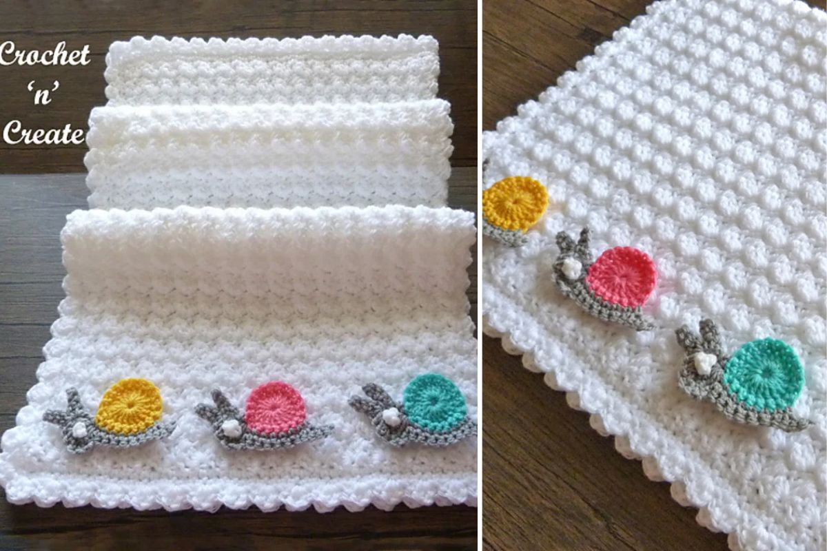A white crocheted blanket with a textured pattern and rows of colorful crocheted snail appliqués along one edge.