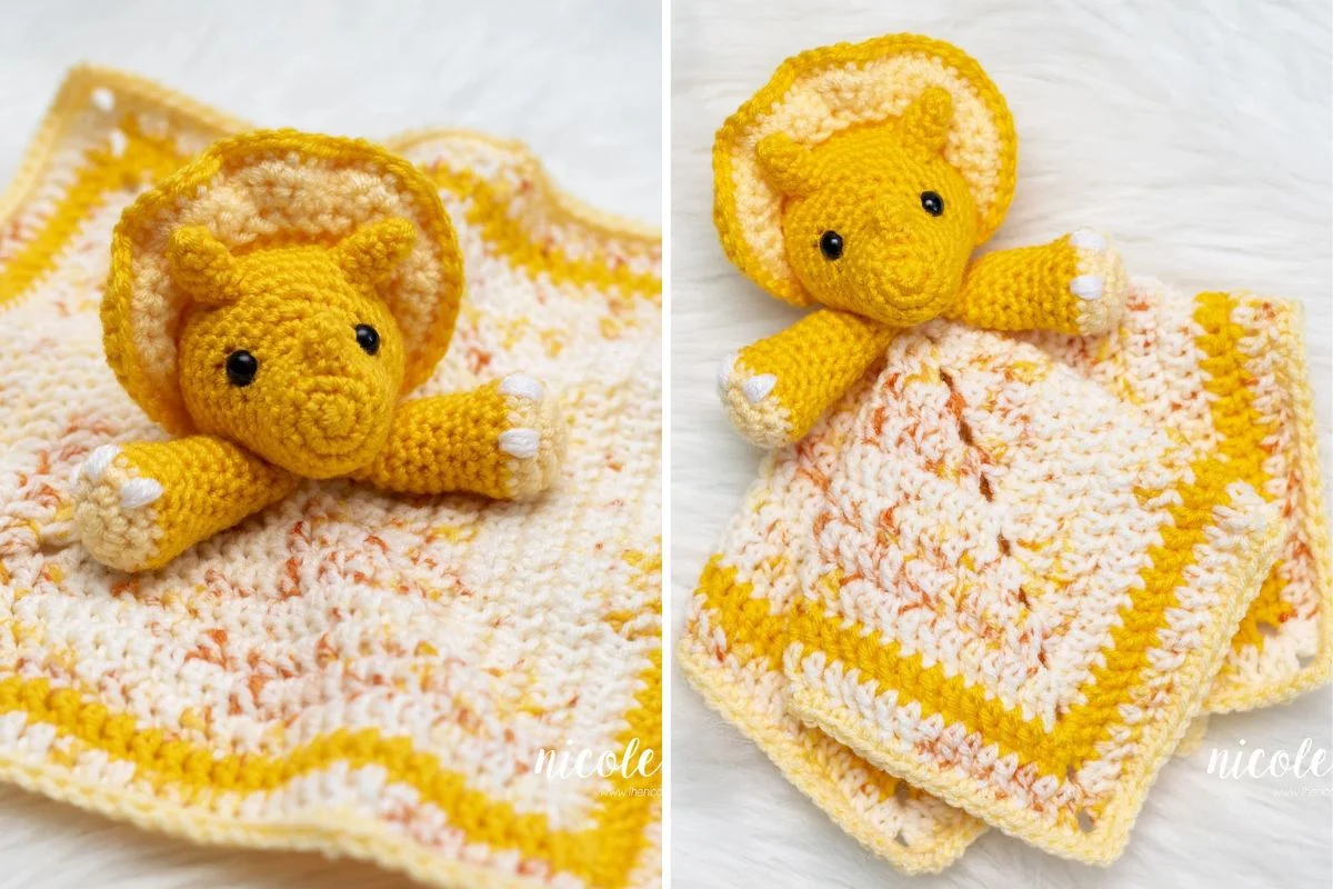 Crocheted yellow triceratops lovey plush attached to a matching yellow and cream baby blanket, shown on a white textured background.