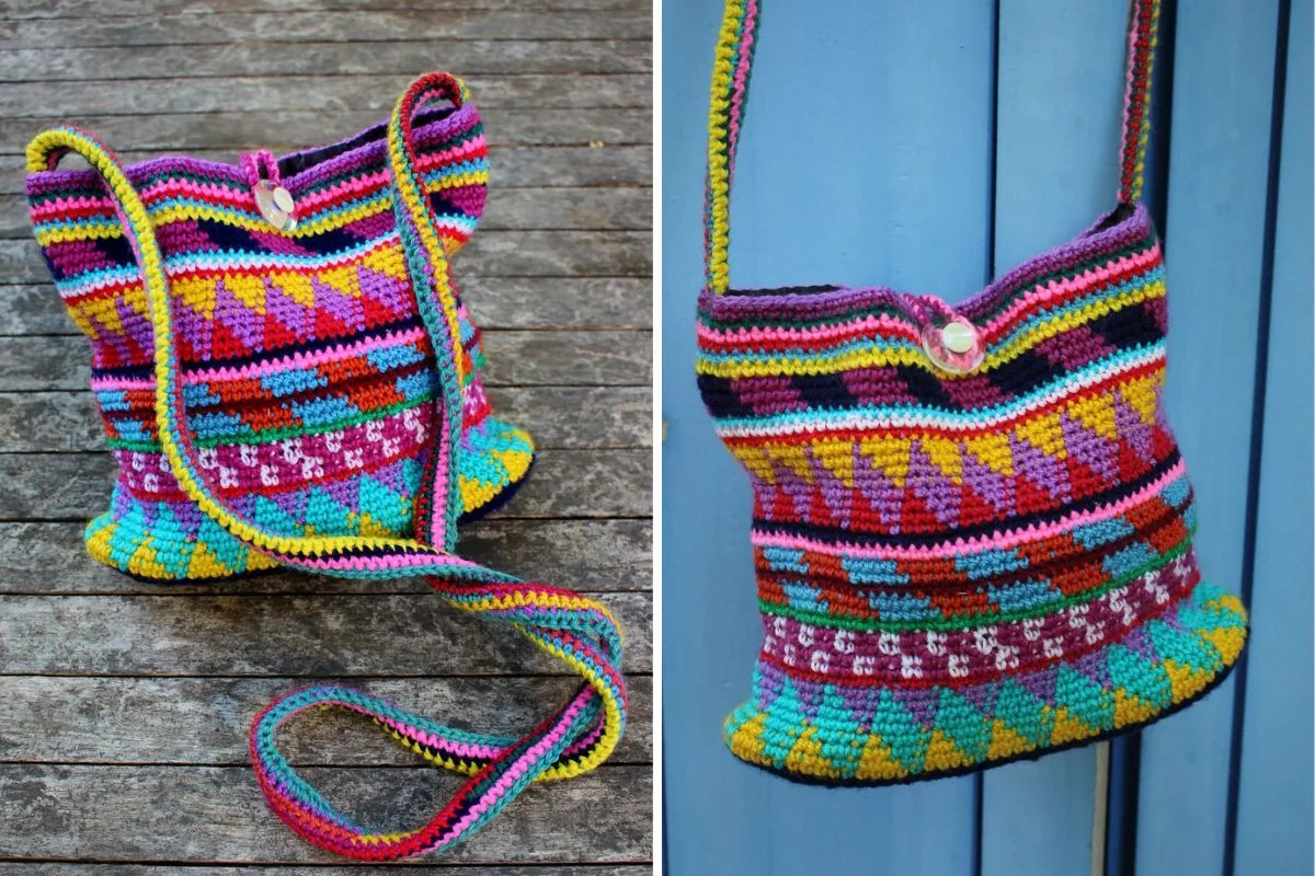 A colorful, hand-crocheted shoulder bag with geometric patterns and a button closure, shown on a wooden surface and against a blue wall.