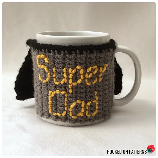 White mug with a gray crocheted cozy that has 