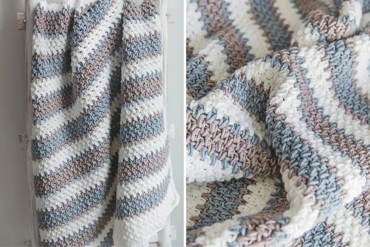 A crocheted blanket with horizontal stripes in white, taupe, and light blue hangs on a rack and is shown in a close-up view highlighting the textured stitches.