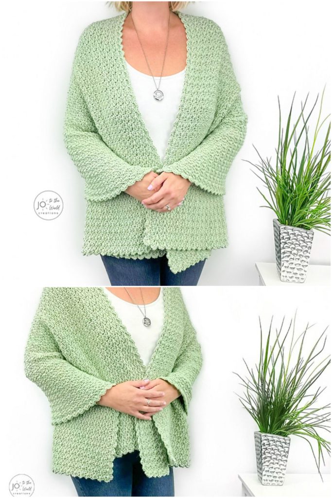 A person wearing a light green knitted cardigan over a white top stands next to a potted green plant on a white table.