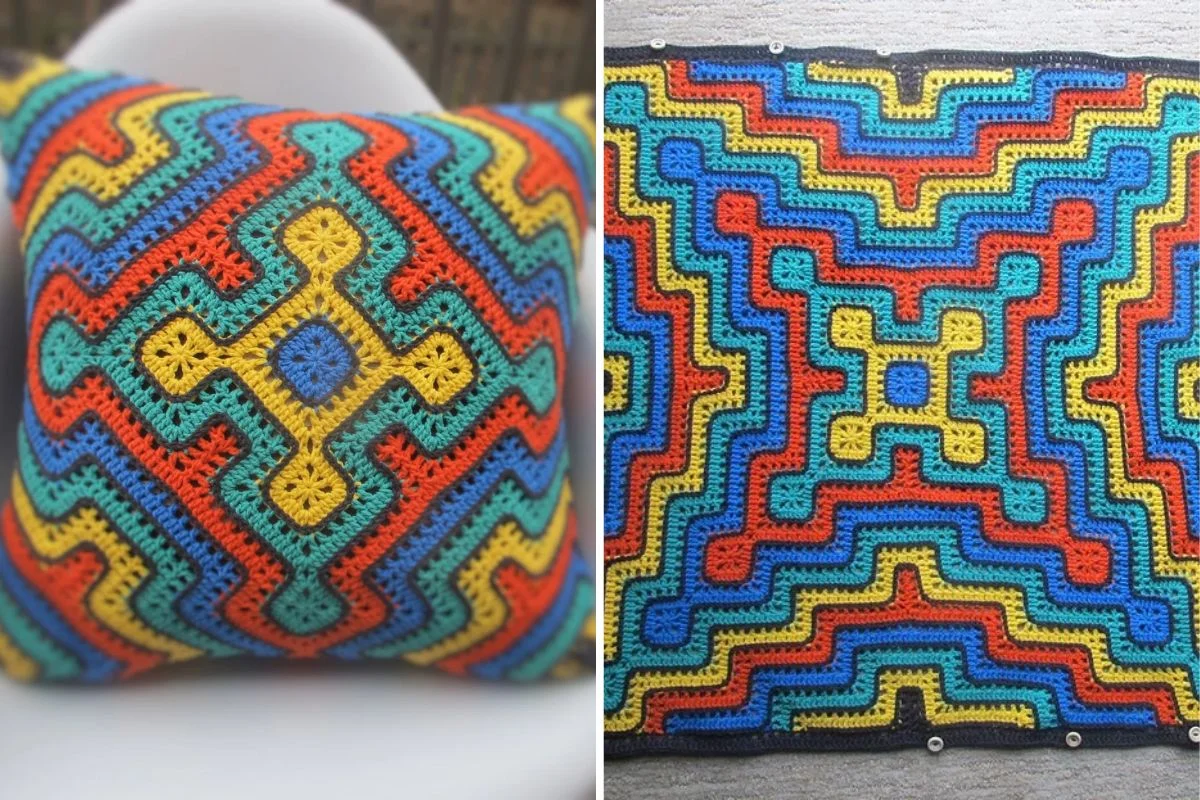 A pillow and a flat fabric display multicolored, geometric crochet patterns in red, yellow, blue, and green yarn.