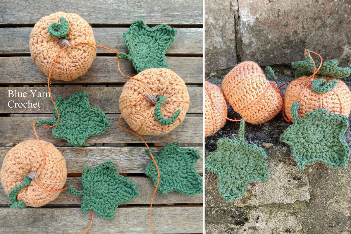 Four crocheted orange pumpkins with green leaves, reminiscent of ivy leaves, are displayed on a wooden surface and stone ground, with some yarn ends visible.