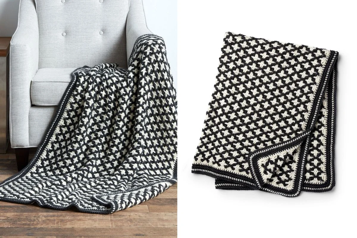 A black and white crocheted blanket with a geometric pattern is draped over a gray chair and shown folded on a white background.