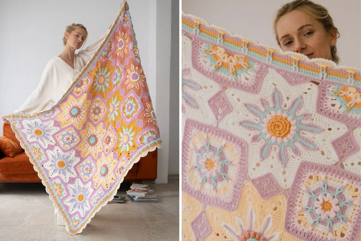A person holds up a colorful crocheted blanket with geometric and floral patterns in pastel shades.