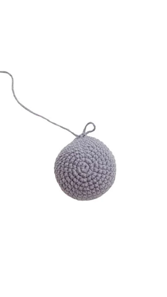 A light grey crocheted piece with a dangling yarn tail, created from a free crochet pattern.