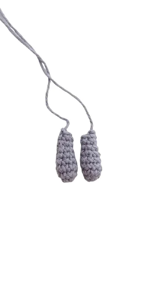 Two small, gray elephant amigurumi shapes suspended by threads.