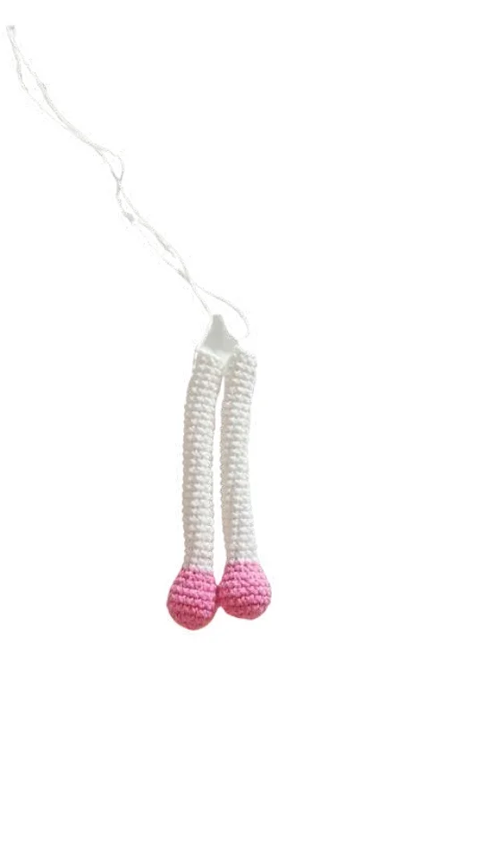 Two crocheted doll legs for a free crochet pumpkin pattern with white upper legs and pink rounded feet, attached by white string.