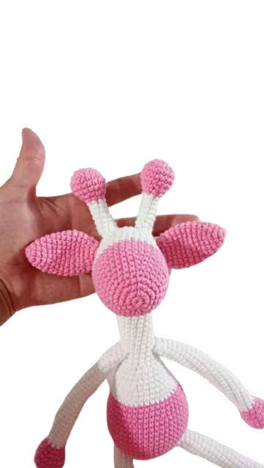 A hand holding a pink and white crocheted giraffe toy next to a free crochet pumpkin pattern.