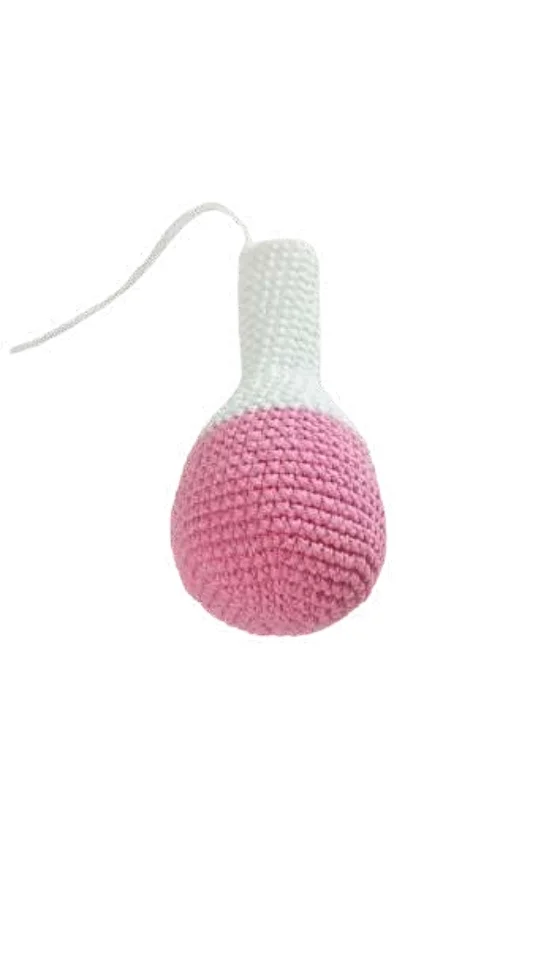 A crochet balloon ornament with a pink rounded base and a white neck, attached to a thin white string, inspired by a crochet pumpkin pattern.