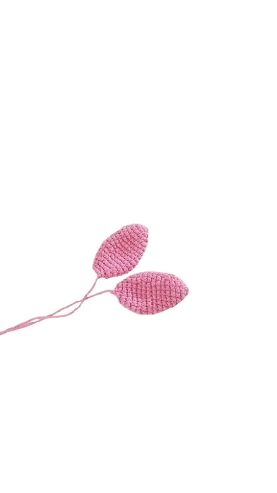 Two small, pink crocheted petals on stems, designed to complement a pumpkin crochet pattern.