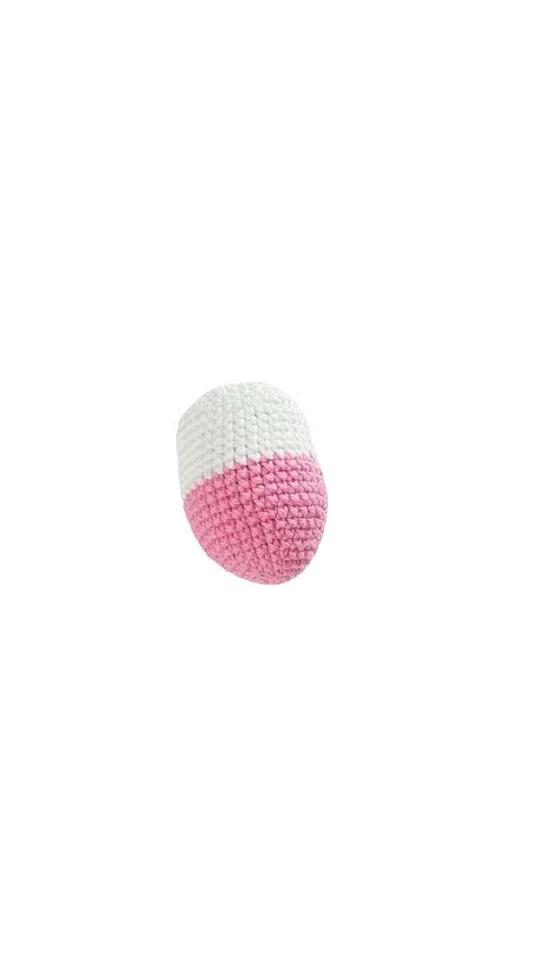 Crocheted capsule-shaped toy, half white and half pink, crafted in a style similar to a giraffe amigurumi.