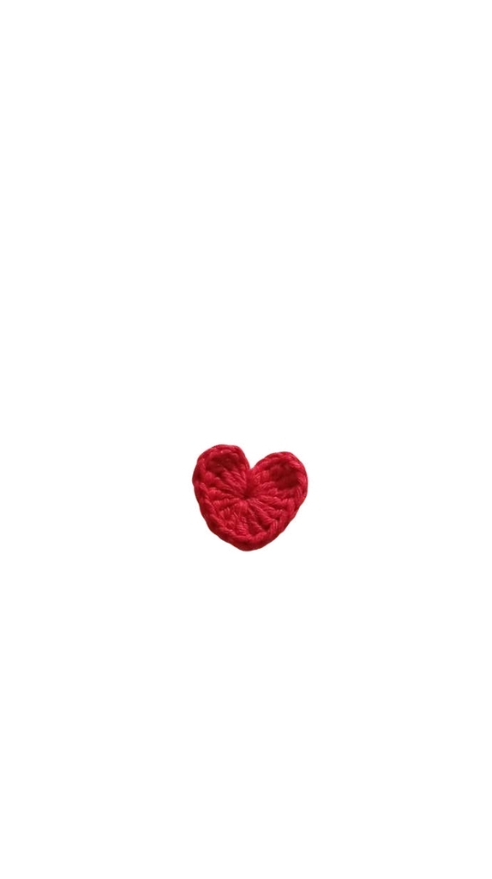 A small red crocheted heart displayed alongside a crochet pumpkin pattern on a white background.