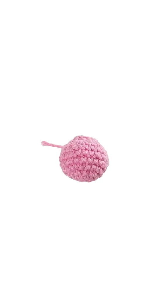 Small pink crocheted sphere resembling a pumpkin, with a short tail.