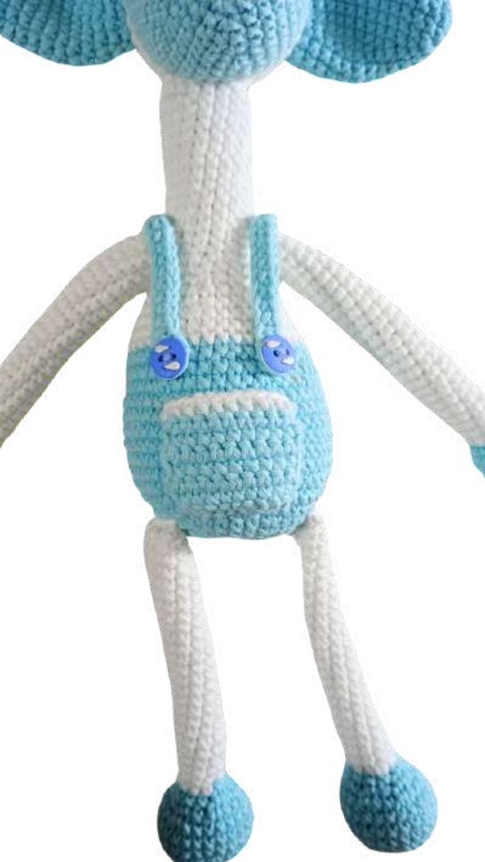 Crocheted giraffe amigurumi with a white body, blue ears, and blue overalls with button straps.