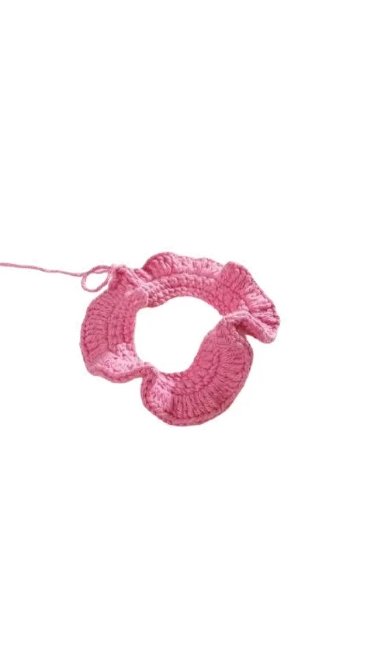 Pink crocheted ruffled scrunchie, perfect for those who enjoy a free crochet pumpkin pattern style.