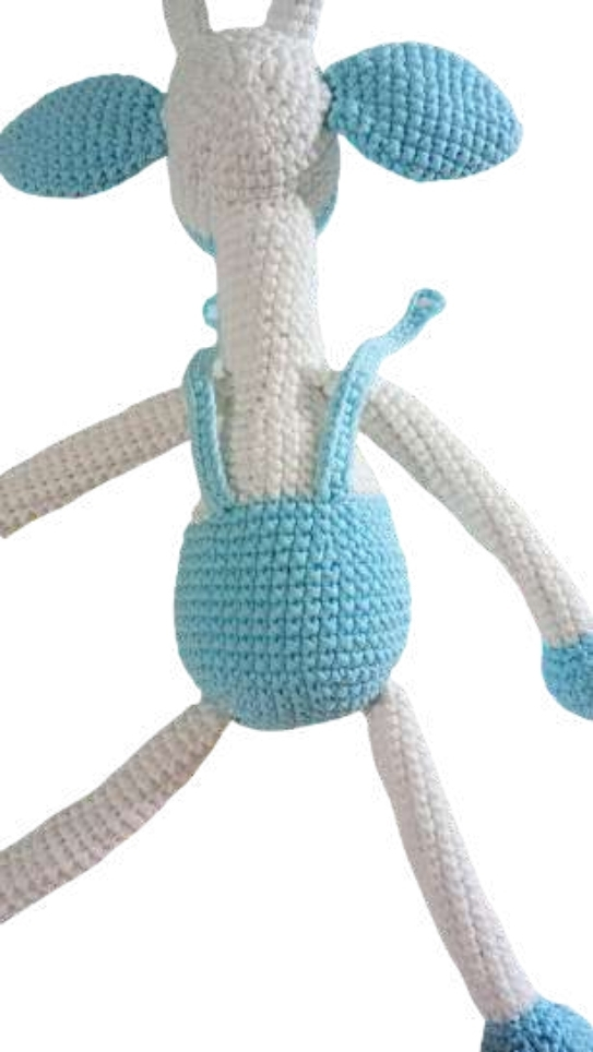 A white crochet giraffe toy wearing light blue overalls, reminiscent of the style found in a crochet pumpkin pattern.